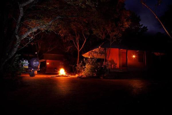 A campfire in front of the bungalow at night
